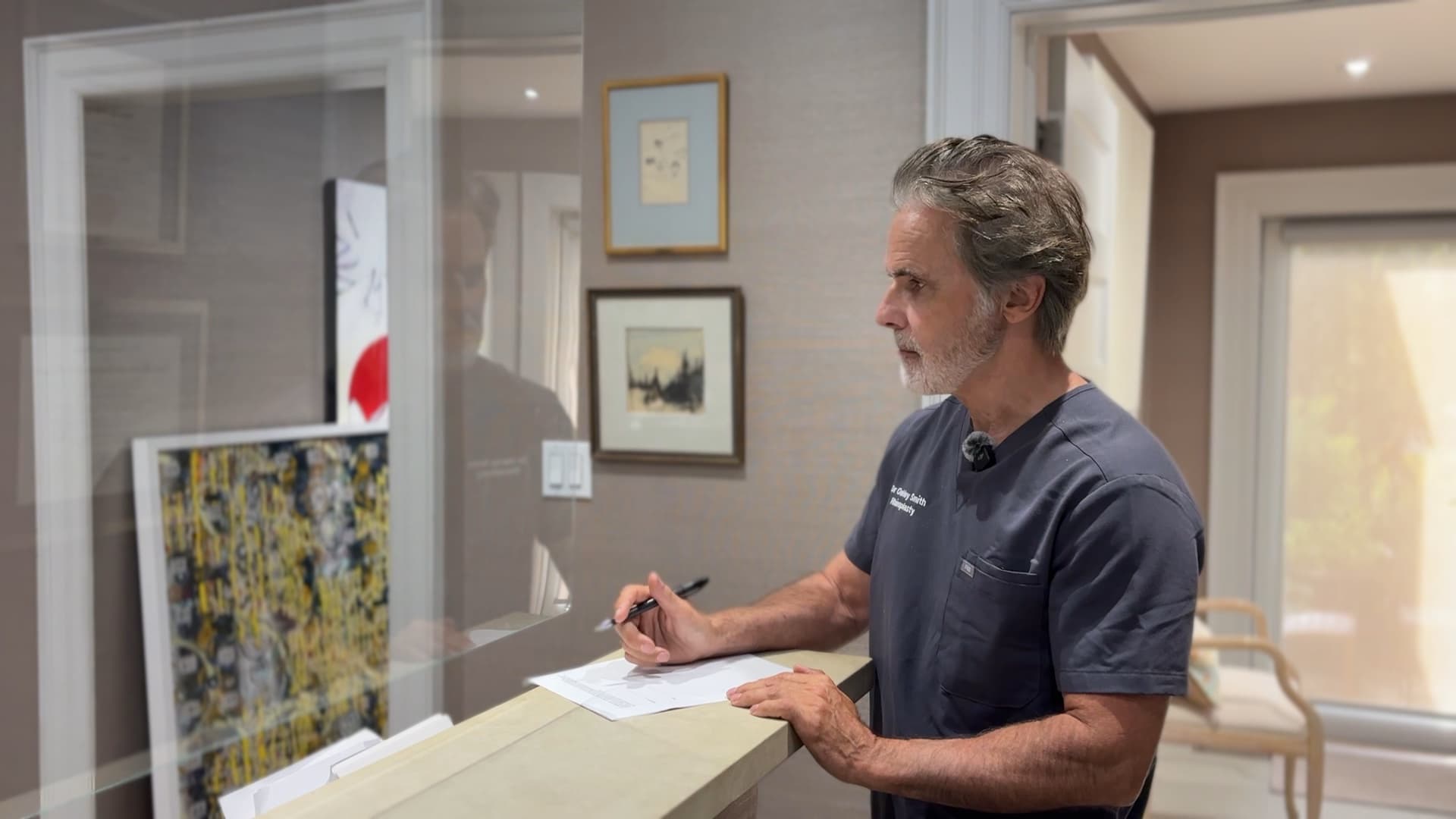 Dr. Oakley Smith writing at the front desk of his practice