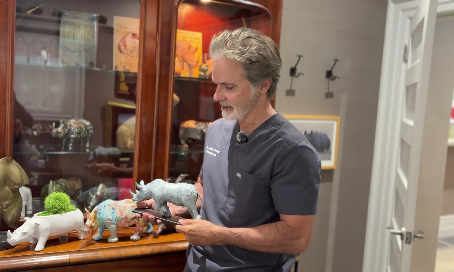 Dr. Oakley Smith holding a rhino sculpture in his clinic