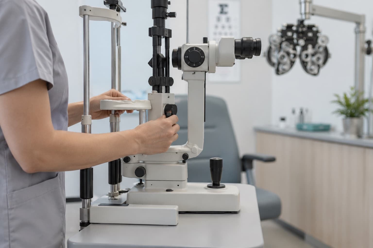 A technician adjusts the chin rest of a slit lamp in a laser eye surgery clinic exam lane